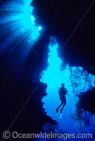 Silhouette Scuba Diver exploring cave photo