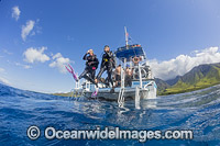 Scuba Divers entering the water by jump entry off the back of a dive boat. Maui, Hawaii, Pacific Ocean, USA.